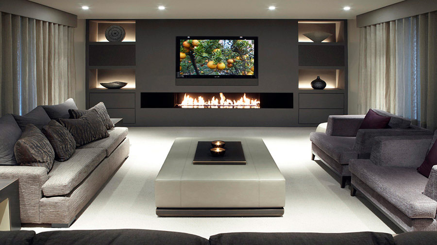 Living room with TV mounted over a modern fireplace.